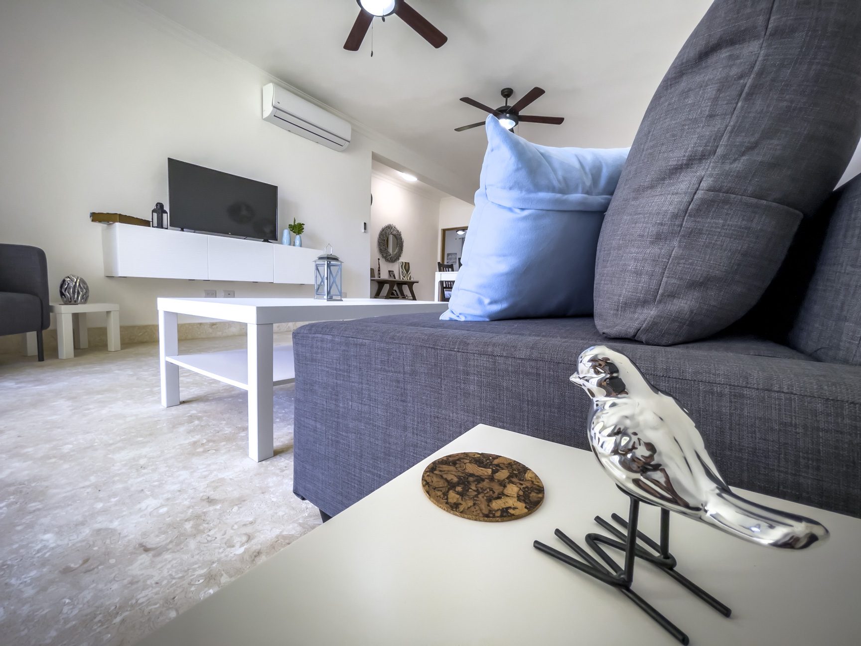 buyDRproperty Modern living room with gray sofa, white table, and bird decor. Home decor. Sosua Real Estate