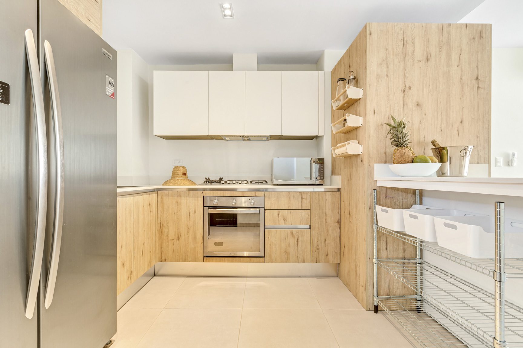 buyDRproperty Modern kitchen with stainless steel appliances, light wood cabinets, and white countertops. Sosua Real Estate