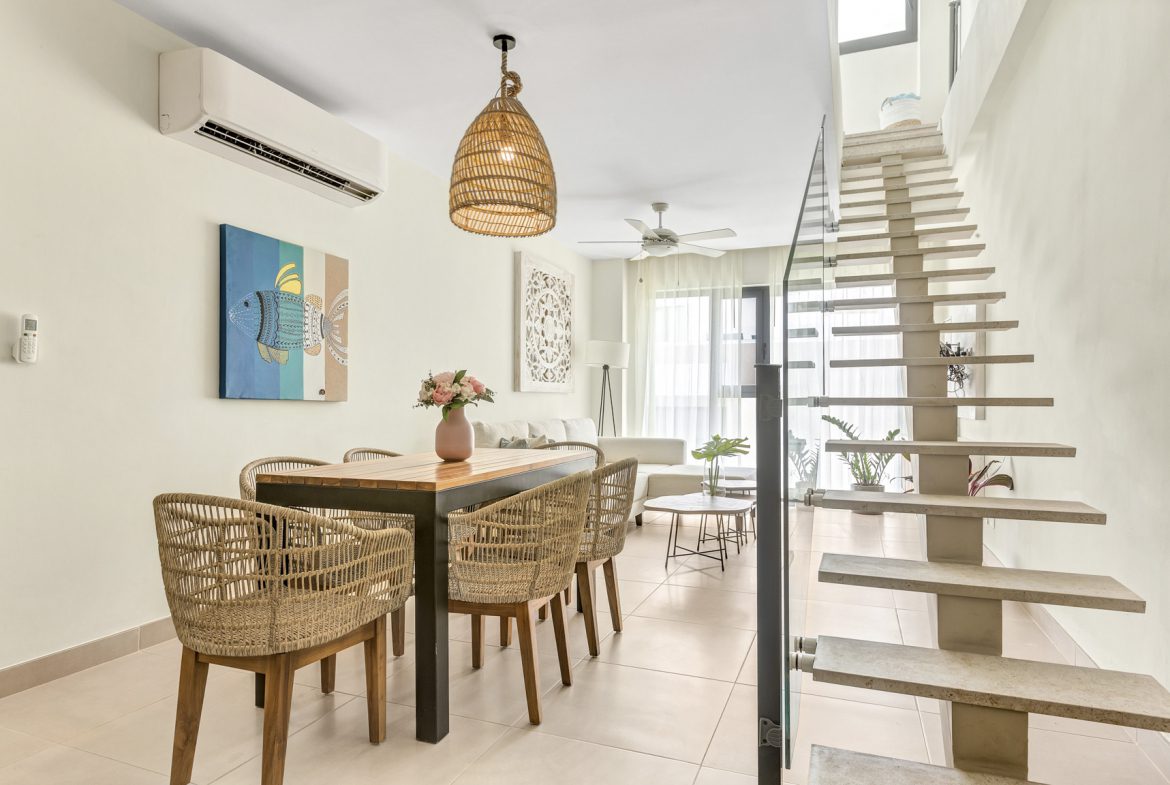 buyDRproperty Bright modern dining area with woven chairs and open staircase. Sosua Real Estate