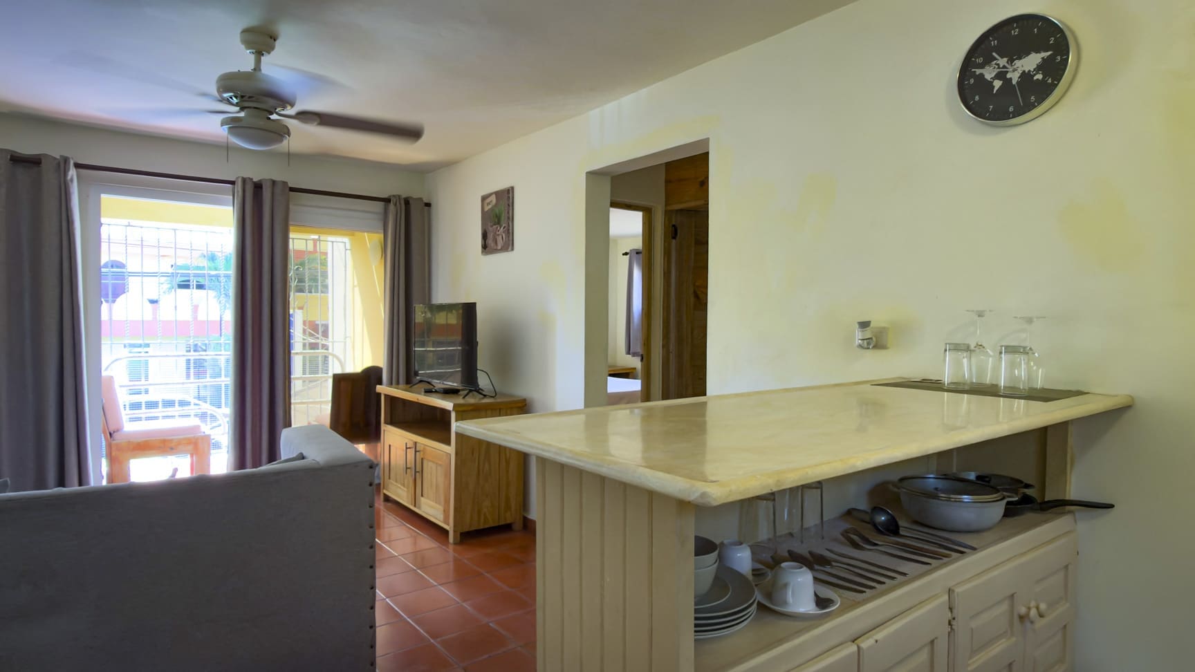 Interior view of a modern apartment kitchen with a breakfast bar and living area.