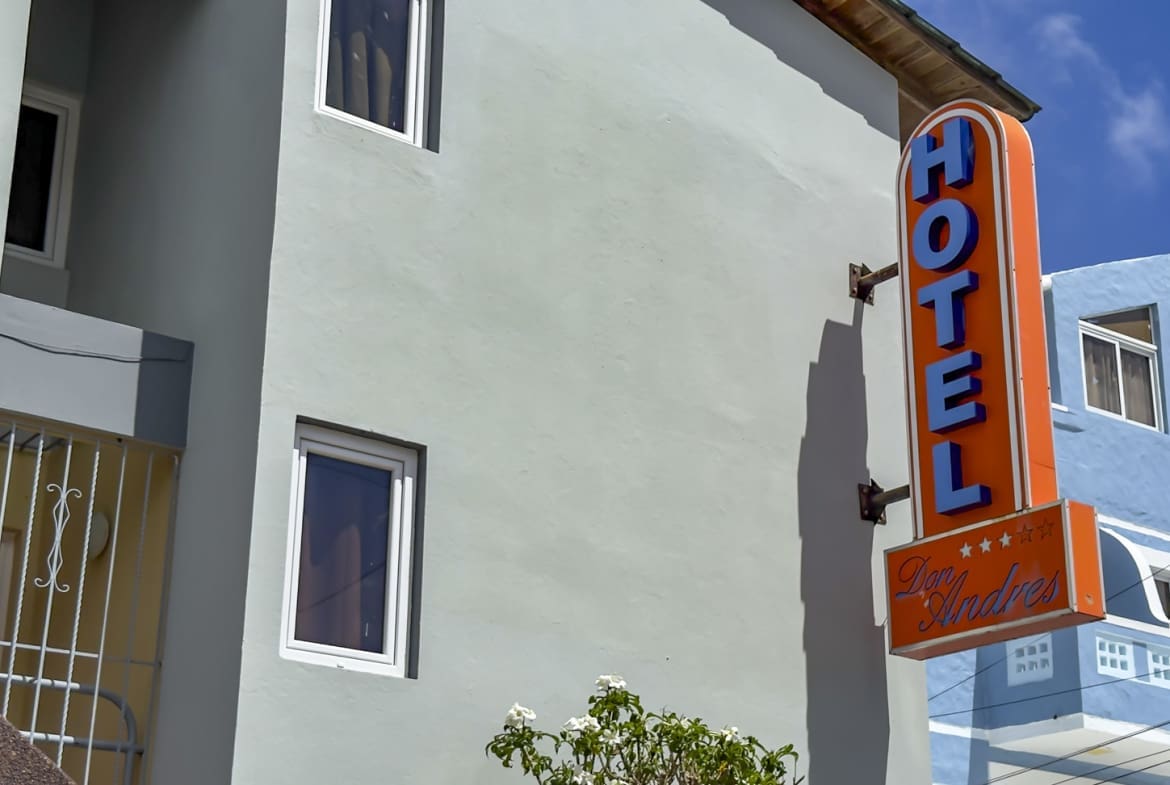 Orange "HOTEL Don Andres" sign on a light blue building