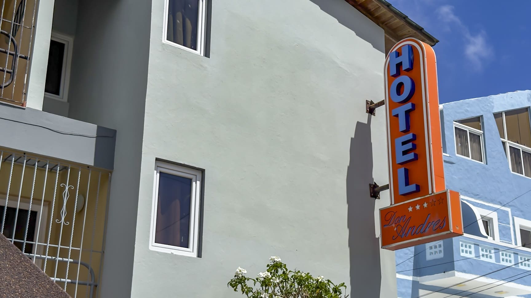 Orange "HOTEL Don Andres" sign on a light blue building