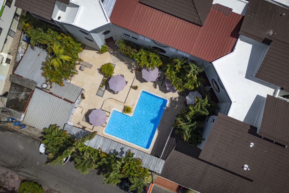 Aerial view of Don Andres hotel resort pool with lounge chairs and palm trees. Sosua Real Estate