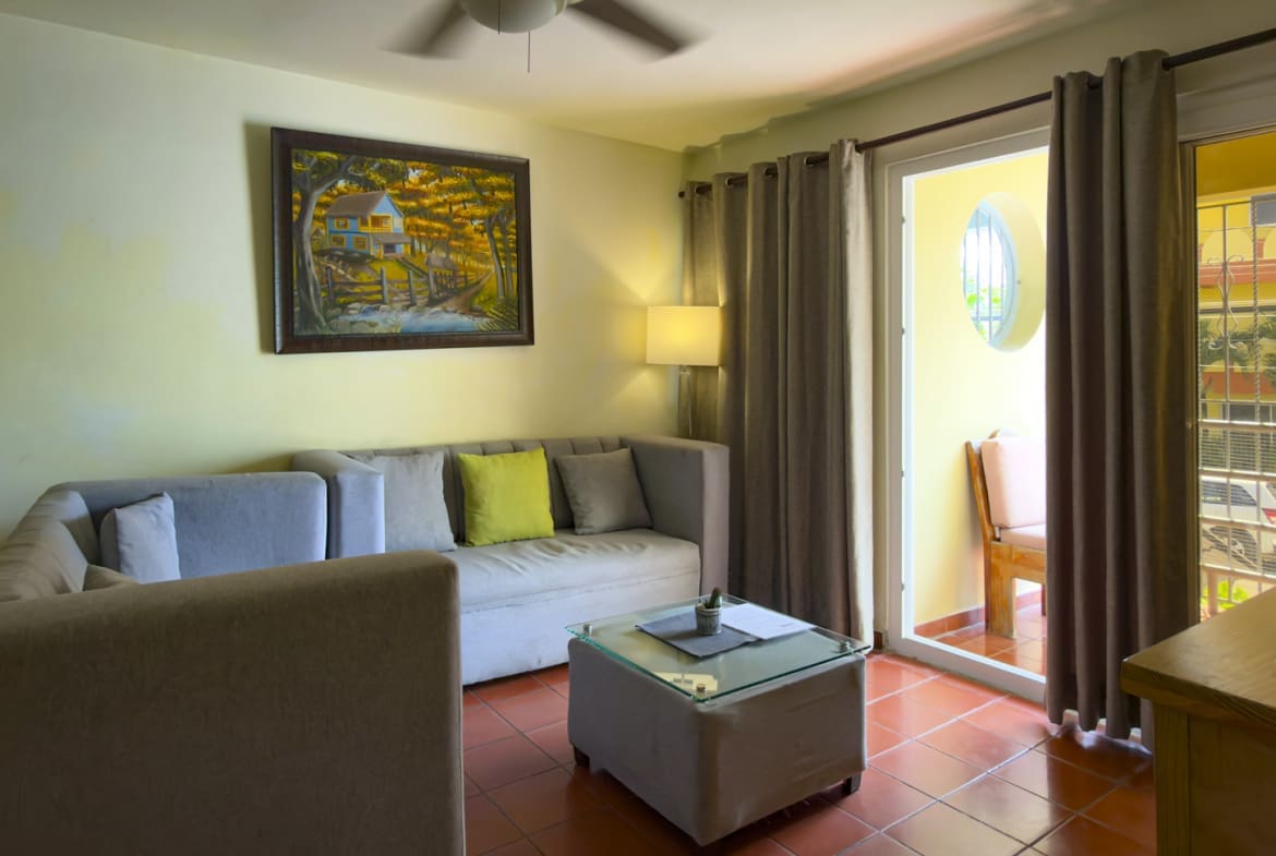 Cozy living room with sectional sofa, coffee table, and balcony door