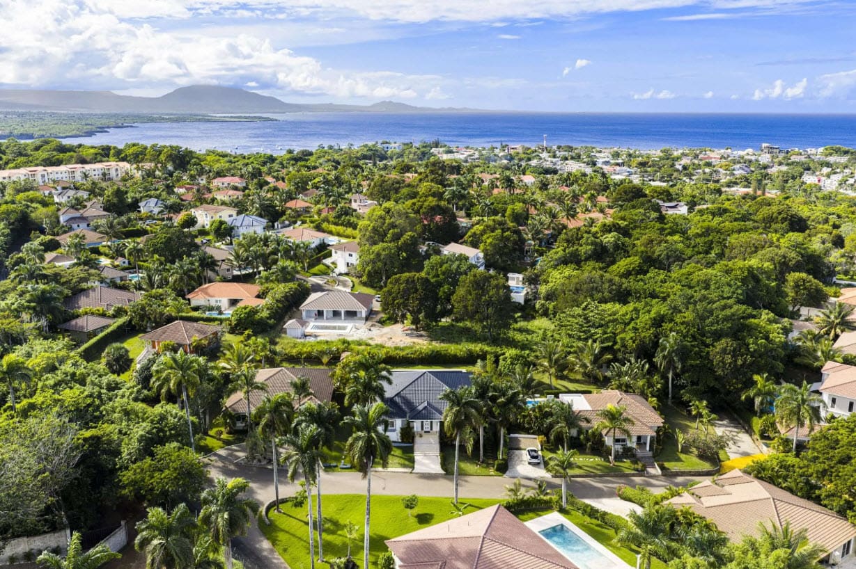 buyDRproperty Aerial view of luxury villas and lush tropical foliage in a coastal community. Sosua Real Estate