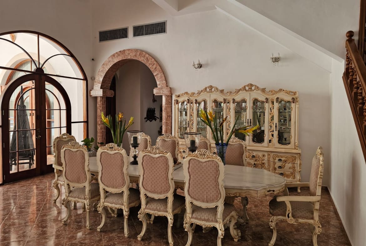 buyDRproperty Elegant dining room with a large ornate table, chairs, and a china cabinet. Sosua Real Estate