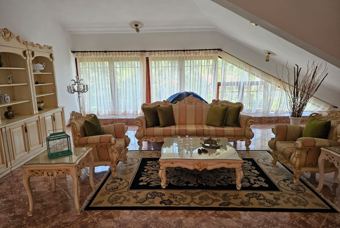 buyDRproperty Elegant living room with ornate furniture, plush seating, and large windows. Sosua Real Estate
