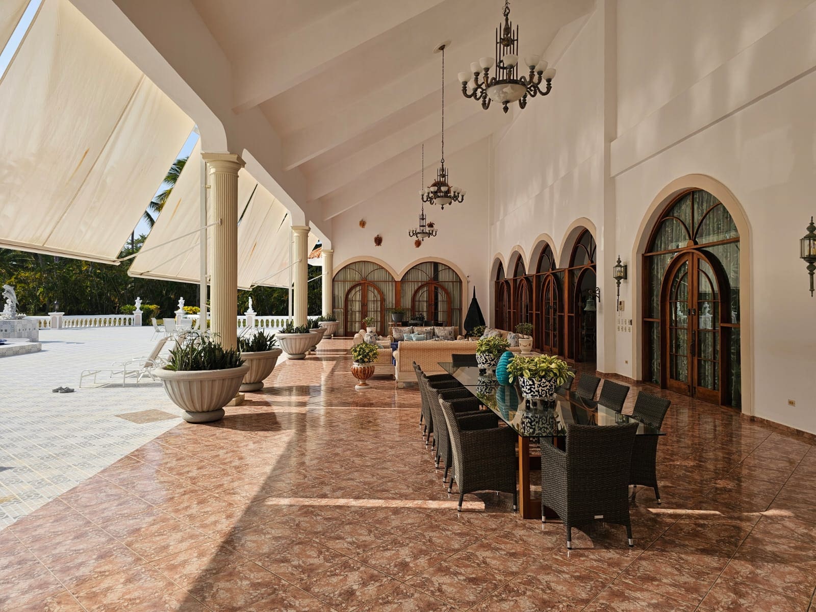 buyDRproperty Spacious covered patio with dining table, chairs, and arched windows Sosua Real Estate