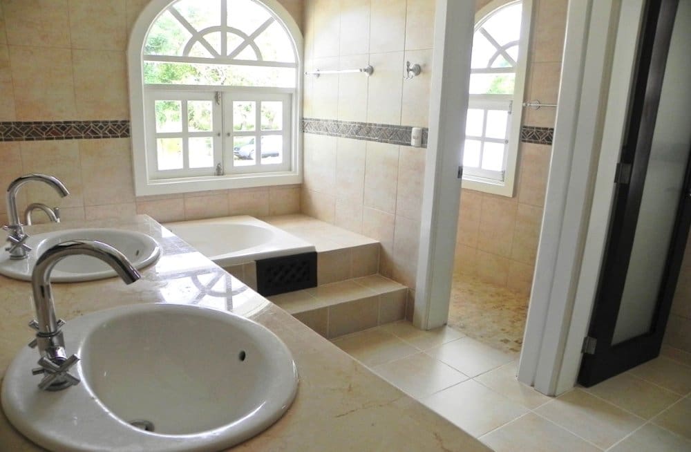buyDRproperty Luxurious bathroom with double vanity, soaking tub, and arched windows Sosua Real Estate