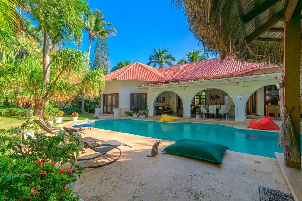 buyDRproperty Luxury villa with pool, palm trees, and covered patio in tropical setting Sosua Real Estate
