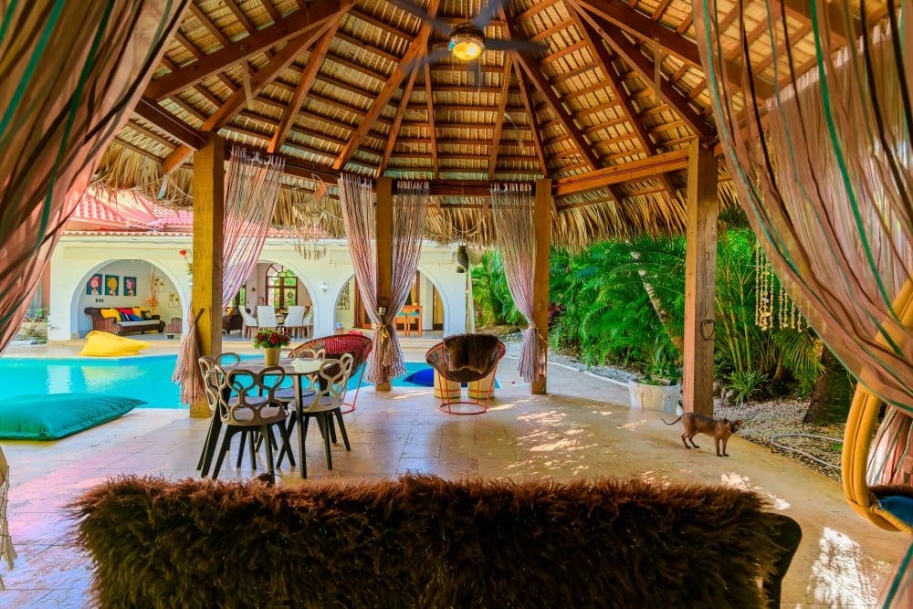 buyDRproperty Open-air thatched-roof cabana with seating and pool view Sosua Real Estate