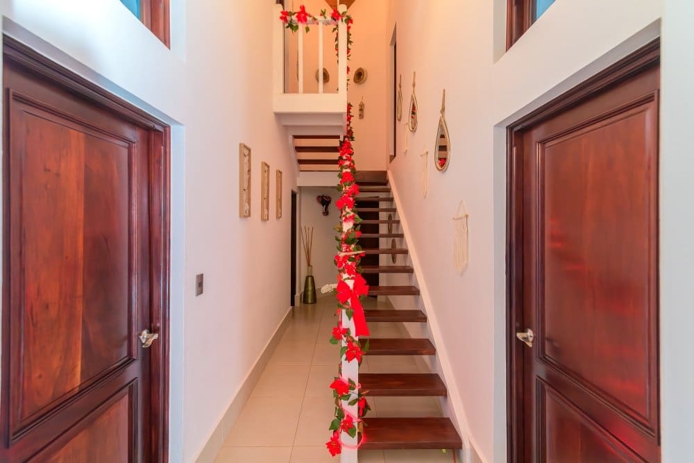 buyDRproperty Wooden doors flank a staircase decorated with red flowers and ribbons Sosua Real Estate