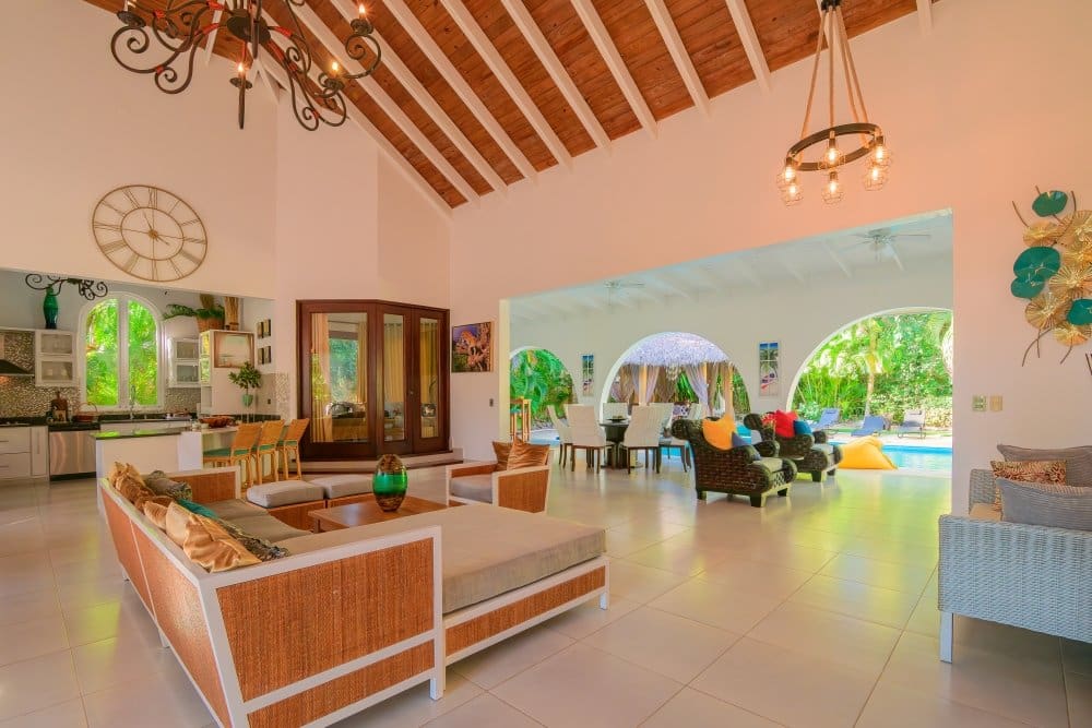 buyDRproperty Spacious, open-plan living area with vaulted ceiling, modern kitchen, and lounge opening to pool. Sosua Real Estate