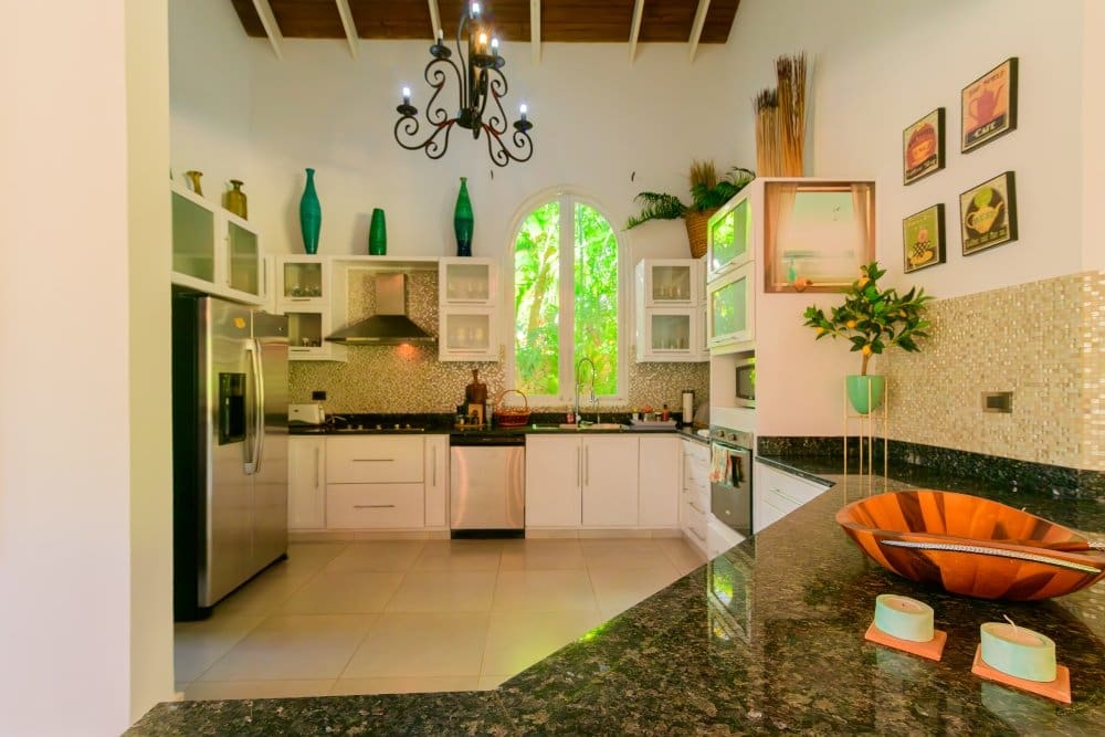 buyDRproperty Modern white kitchen with stainless steel appliances and arched window Sosua Real Estate