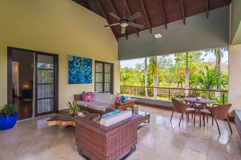 buyDRproperty Spacious covered patio with outdoor furniture and tropical views Sosua Real Estate