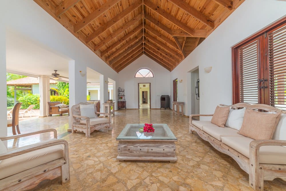 buyDRproperty Spacious living room with vaulted wood ceiling, light wood furniture, and tiled floor. Sosua Real Estate