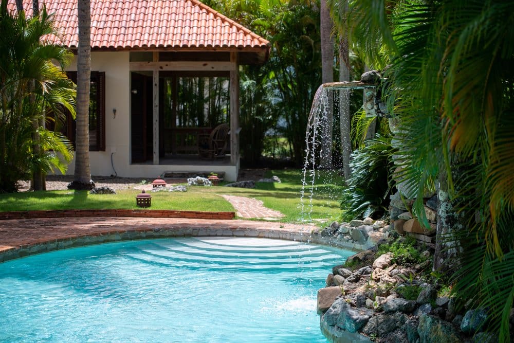 buyDRproperty Tropical villa with pool and waterfall, lush green palm trees Sosua Real Estate