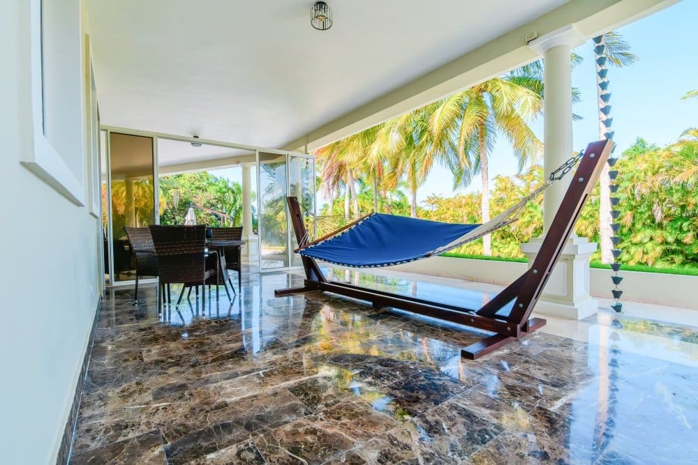 buyDRproperty Blue hammock on a marble patio with palm trees in the background Sosua Real Estate