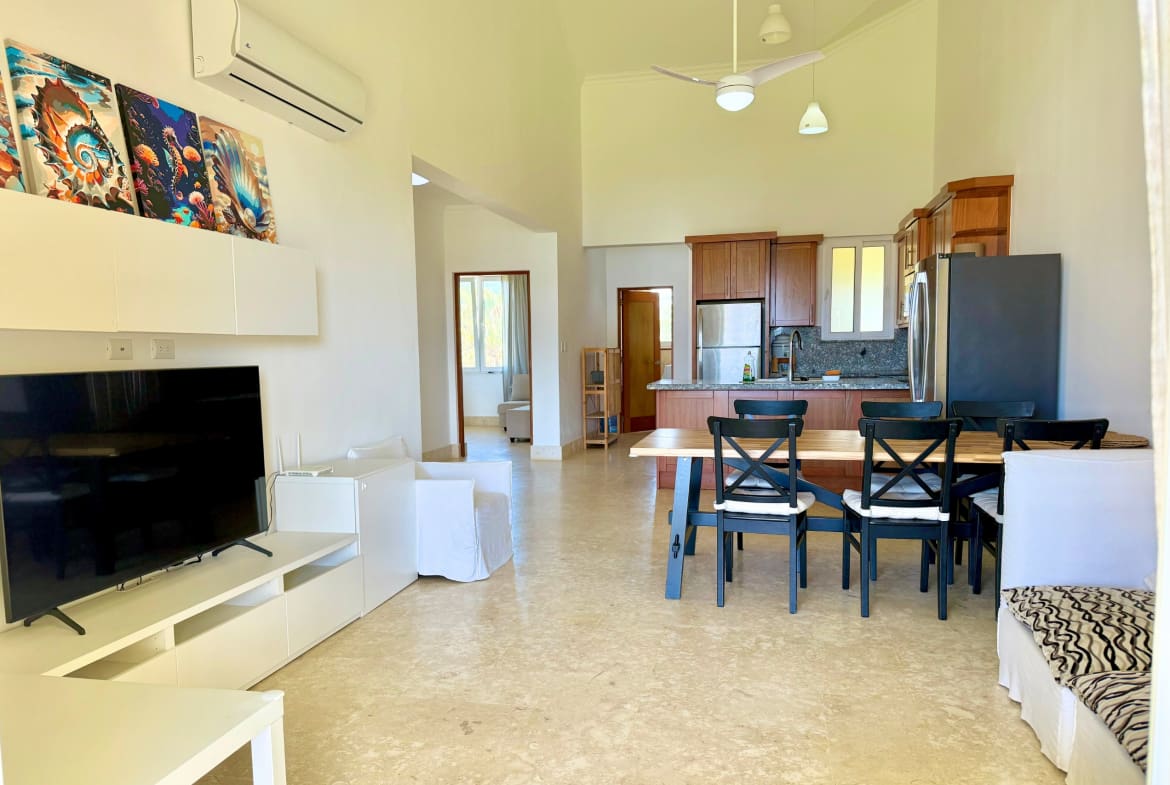 Spacious open-plan living, dining, and kitchen area with modern furniture.