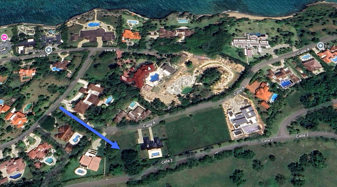 Aerial view of luxury villas and construction sites near a coastline.
