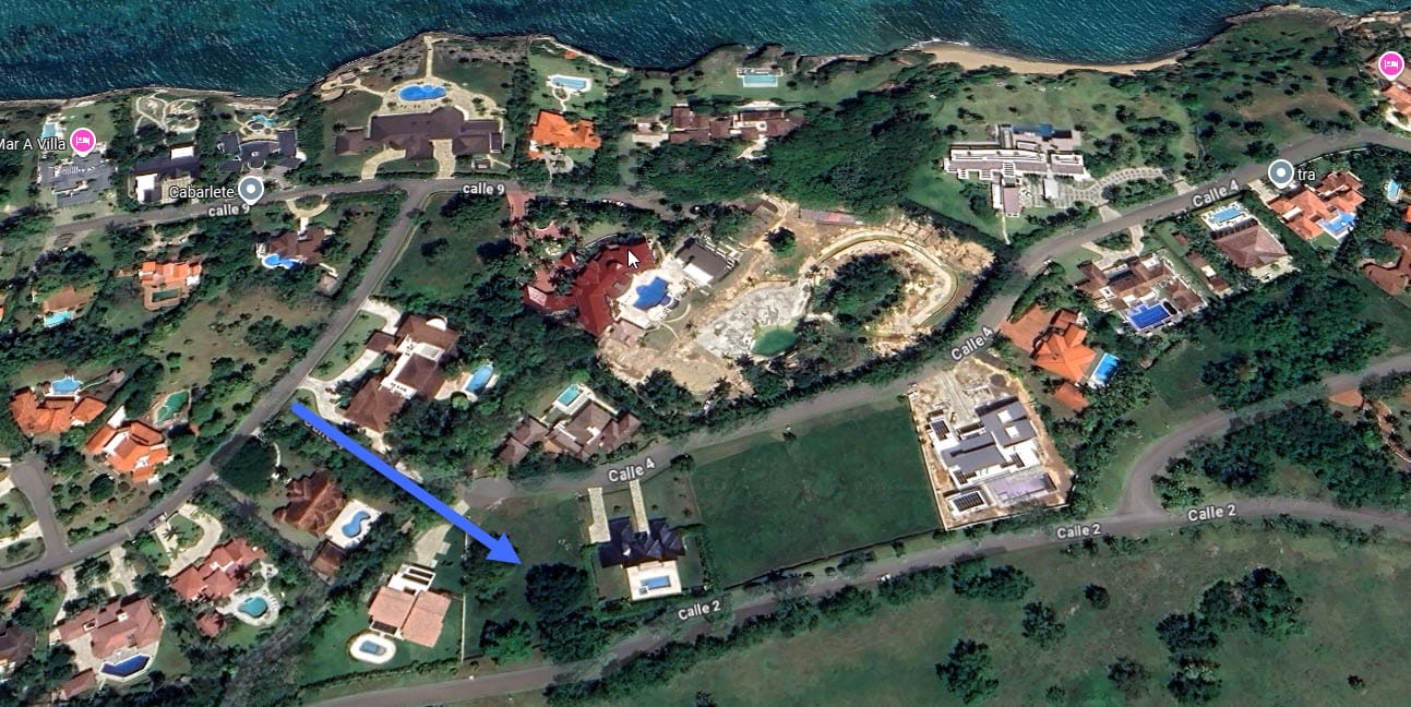 Aerial view of luxury villas and construction sites near a coastline.