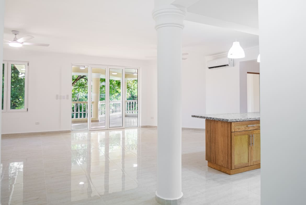 Bright open-plan living room with balcony in 3-bedroom Hispaniola Beach condo in Sosua