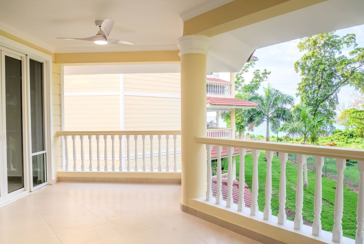 Spacious covered balcony overlooking gardens at Hispaniola Beach condo in Sosua