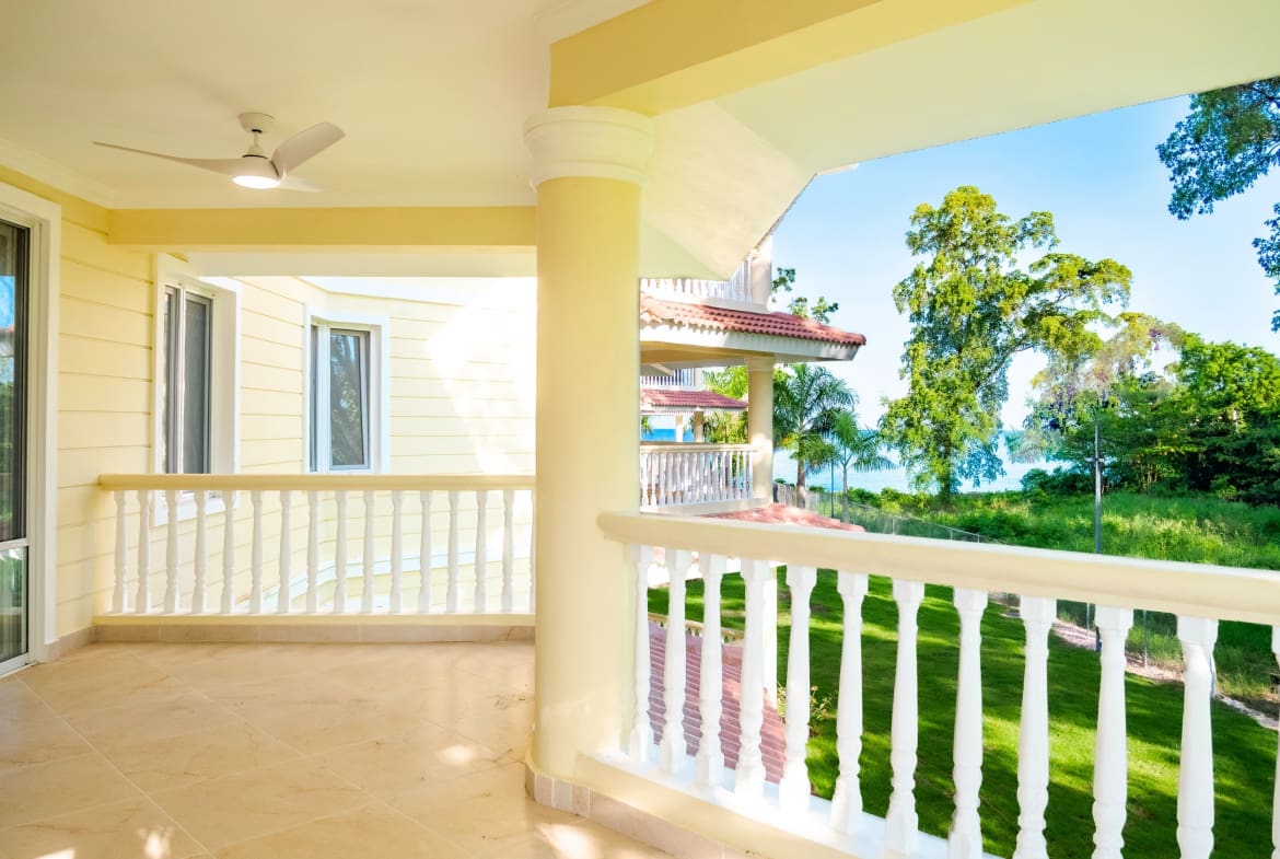 Covered balcony overlooking tropical gardens at 3-bedroom Hispaniola Beach condo in Sosua