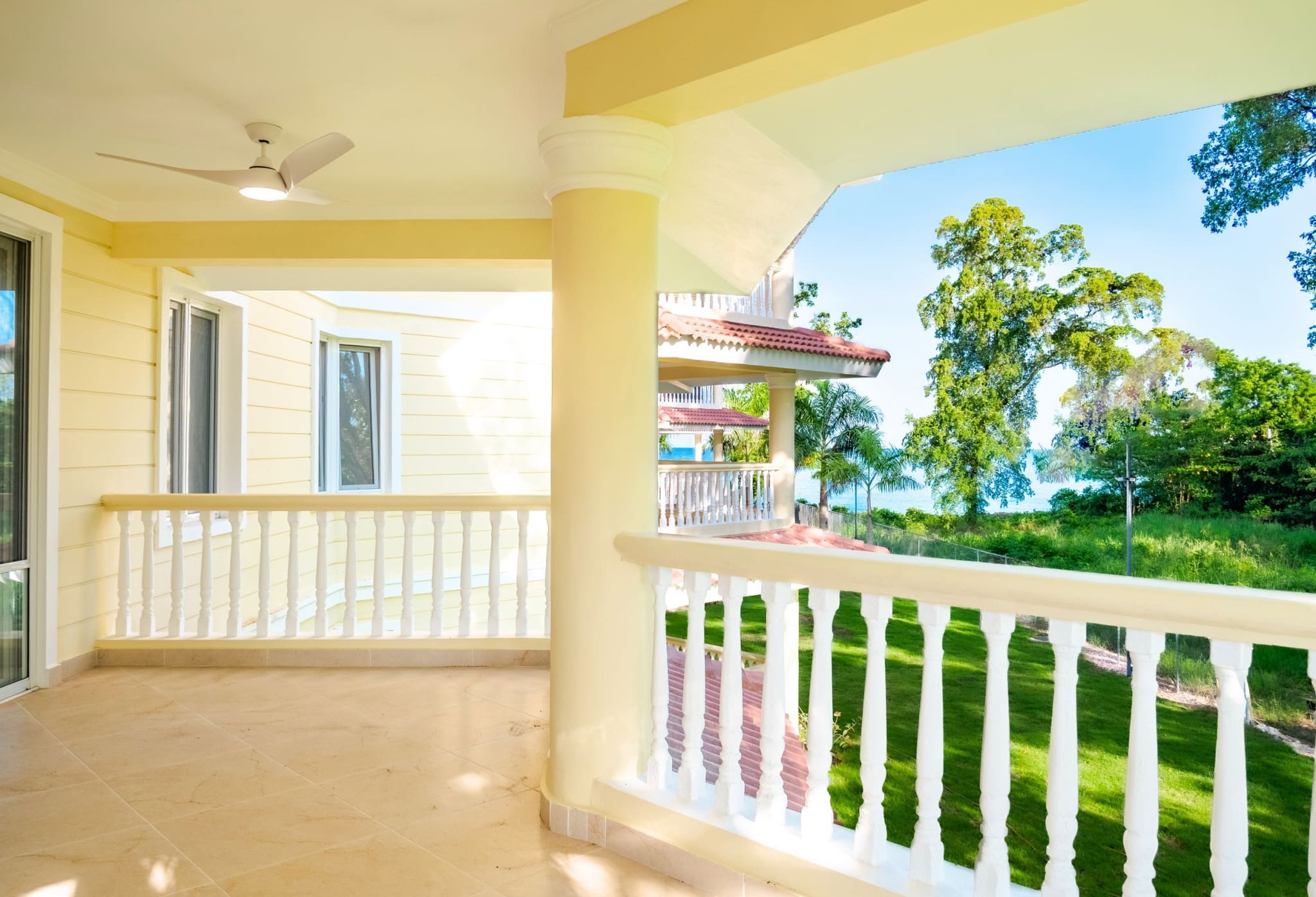 Covered balcony overlooking tropical gardens at 3-bedroom Hispaniola Beach condo in Sosua