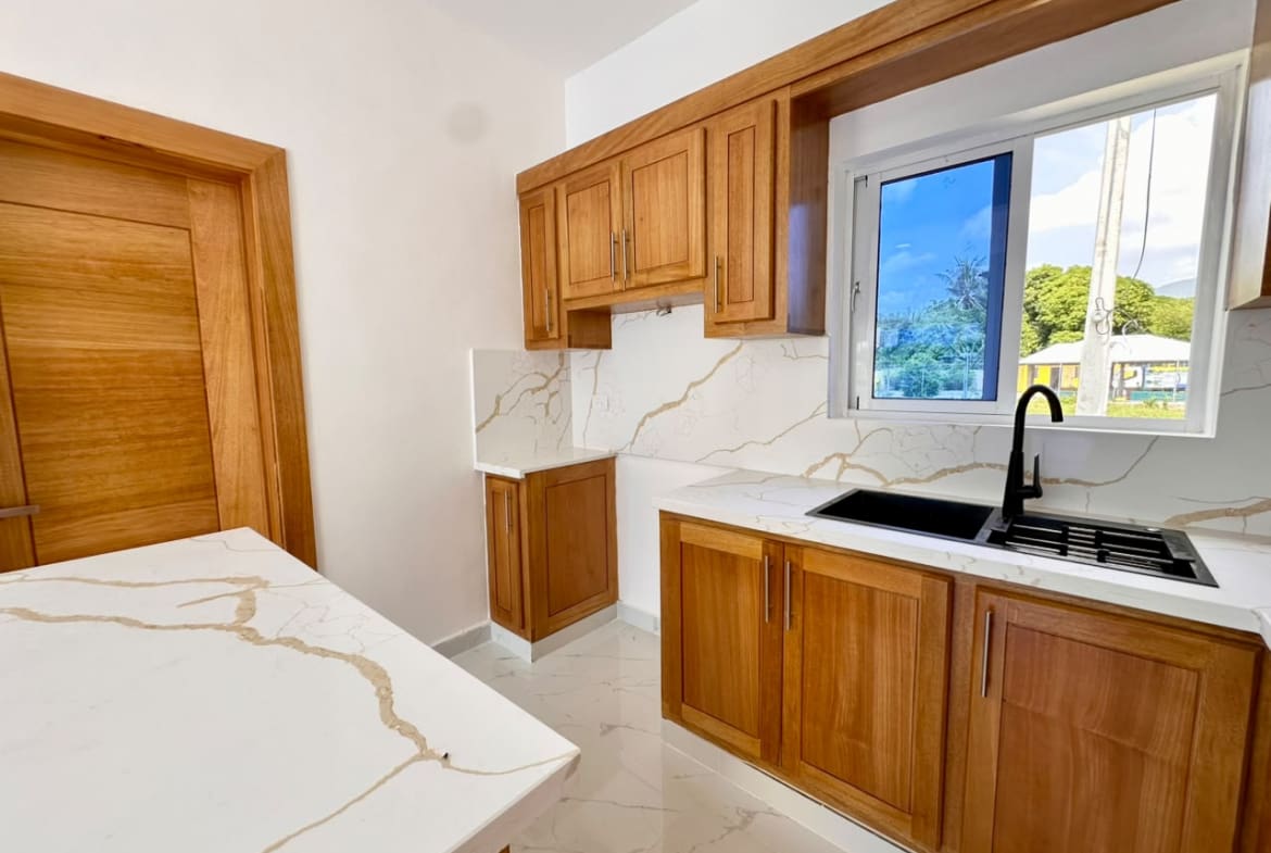 buyDRproperty countertops, wood cabinets, and black sink. Sosua Real Estate