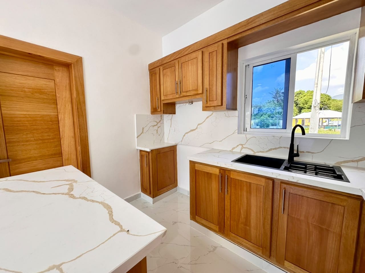 buyDRproperty countertops, wood cabinets, and black sink. Sosua Real Estate