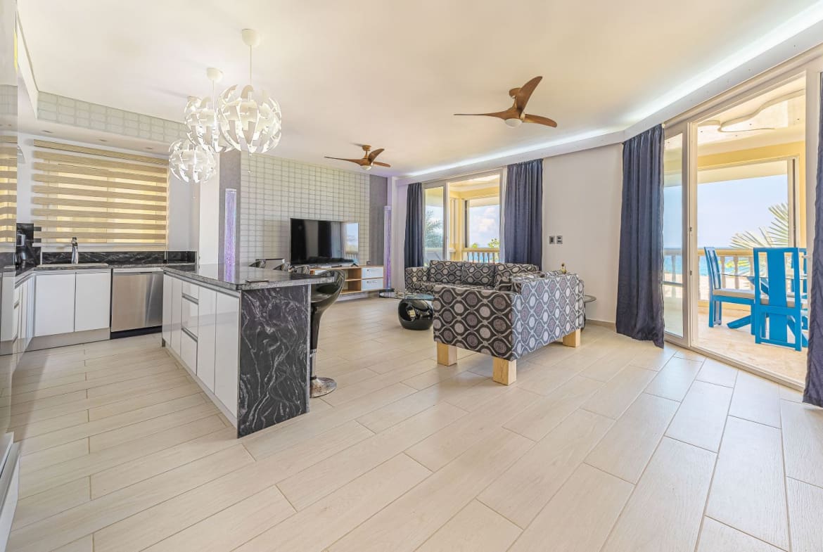 Modern living room and kitchen with ocean view balcony in a beach resort.