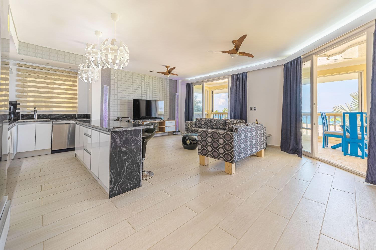 Modern living room and kitchen with ocean view balcony in a beach resort.