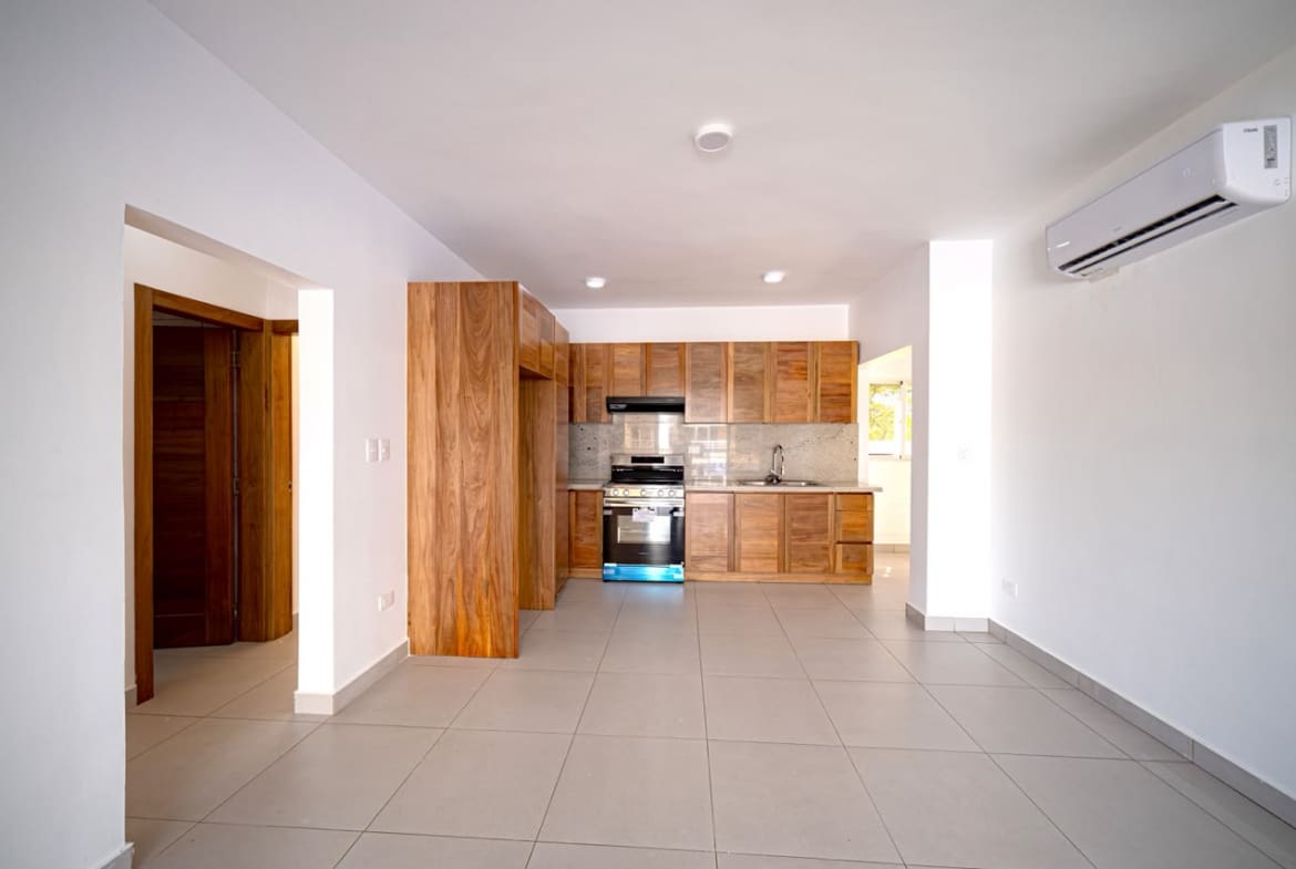 buyDRproperty Modern kitchen with wooden cabinets, stainless steel appliances, and tile flooring. Sosua Real Estate