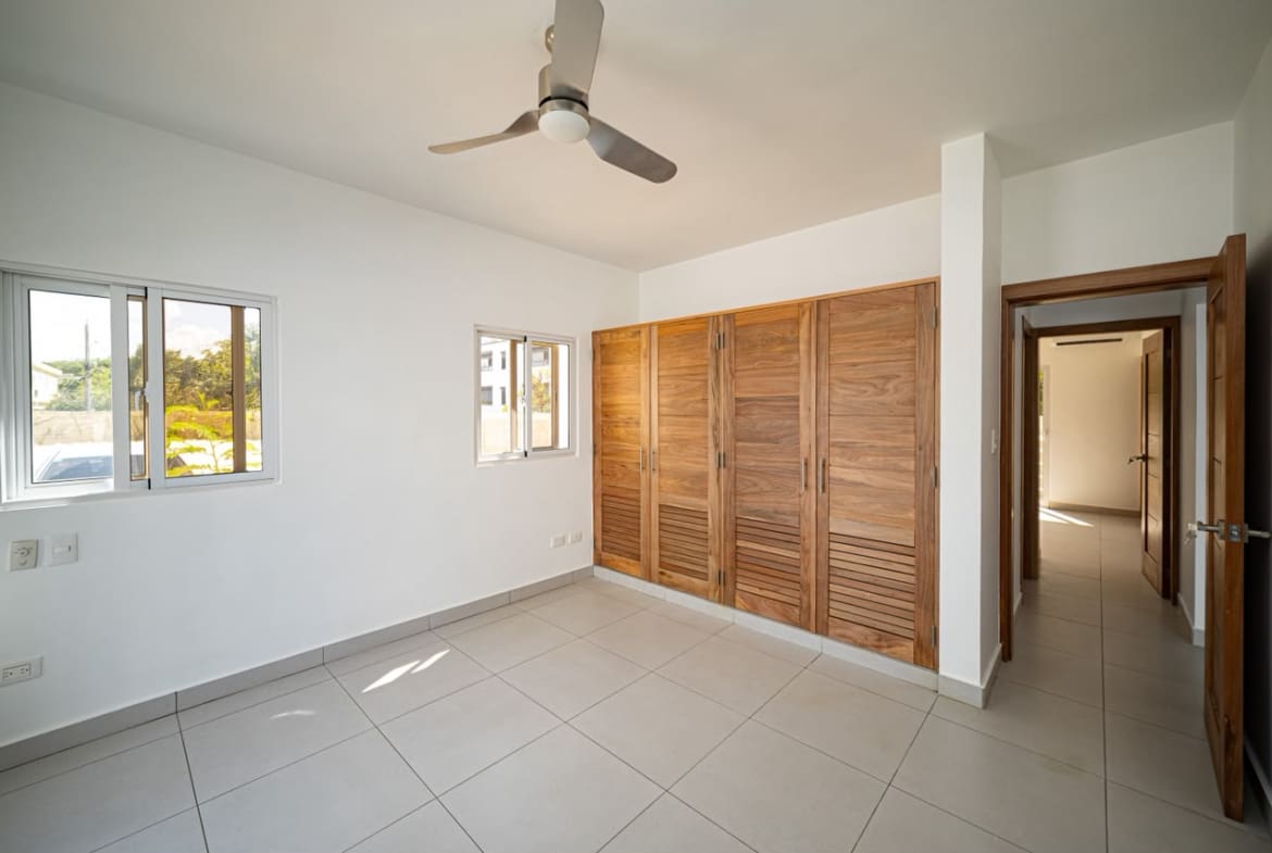 buyDRproperty Modern bedroom with wooden built-in wardrobes and ceiling fan. Sosua Real Estate