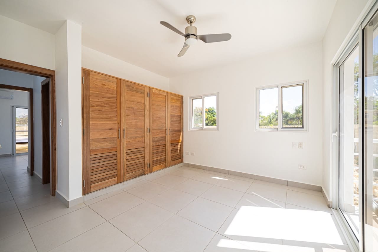 buyDRproperty Empty modern bedroom with large wooden closet, white walls, and ceiling fan. Sosua Real Estate
