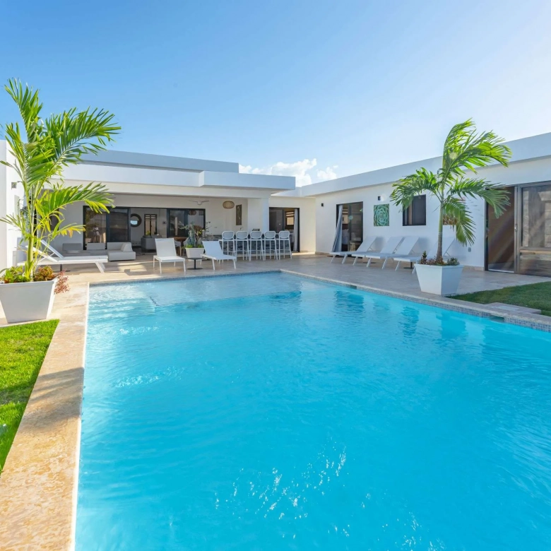 buyDRproperty Modern white villa with a bright blue swimming pool and palm trees Sosua Real Estate