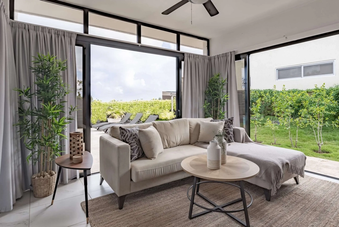 buyDRproperty Modern living room with sectional sofa, coffee table, and outdoor view Sosua Real Estate