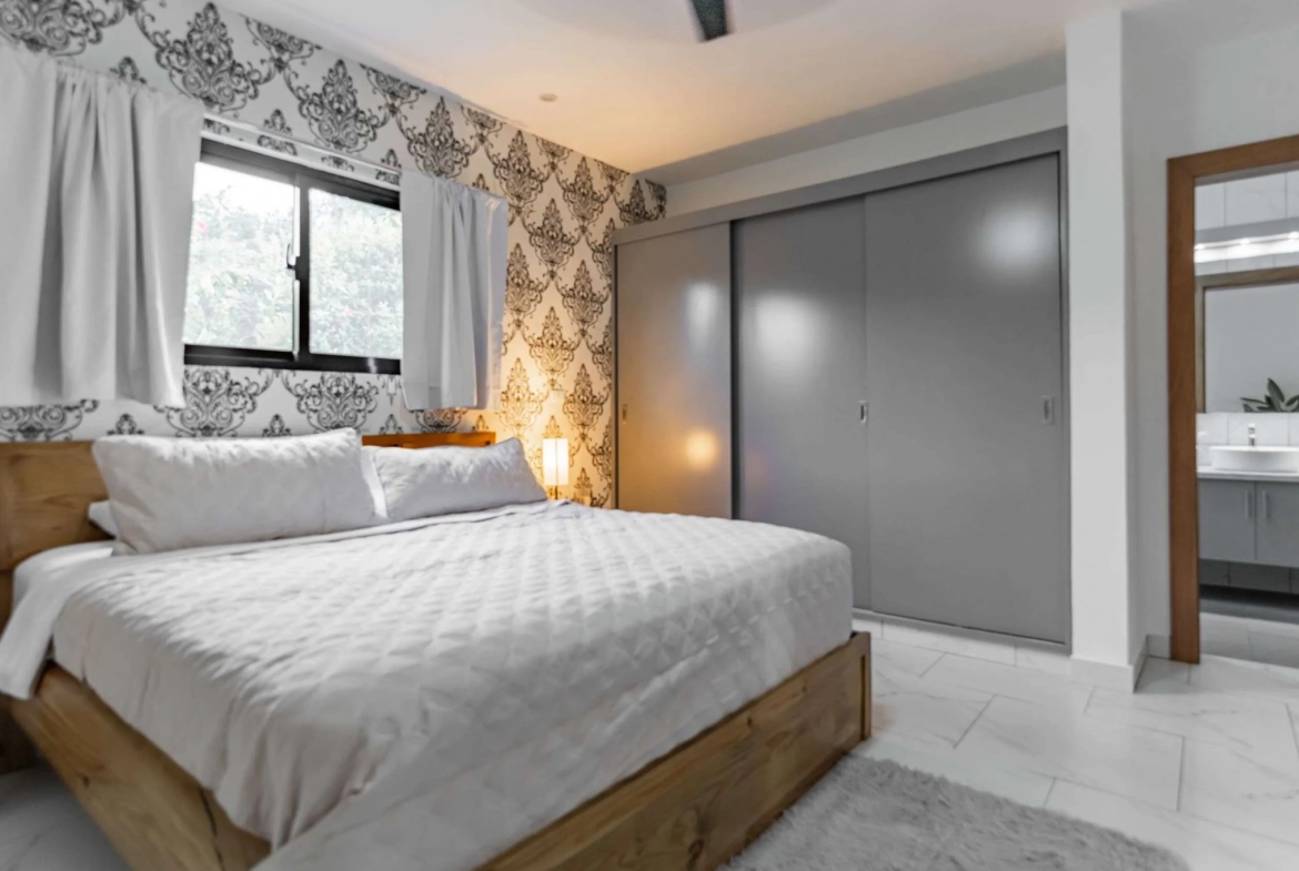3BR Villa Sunseeker Casa Linda master bedroom with wood bed and patterned wallpaper.