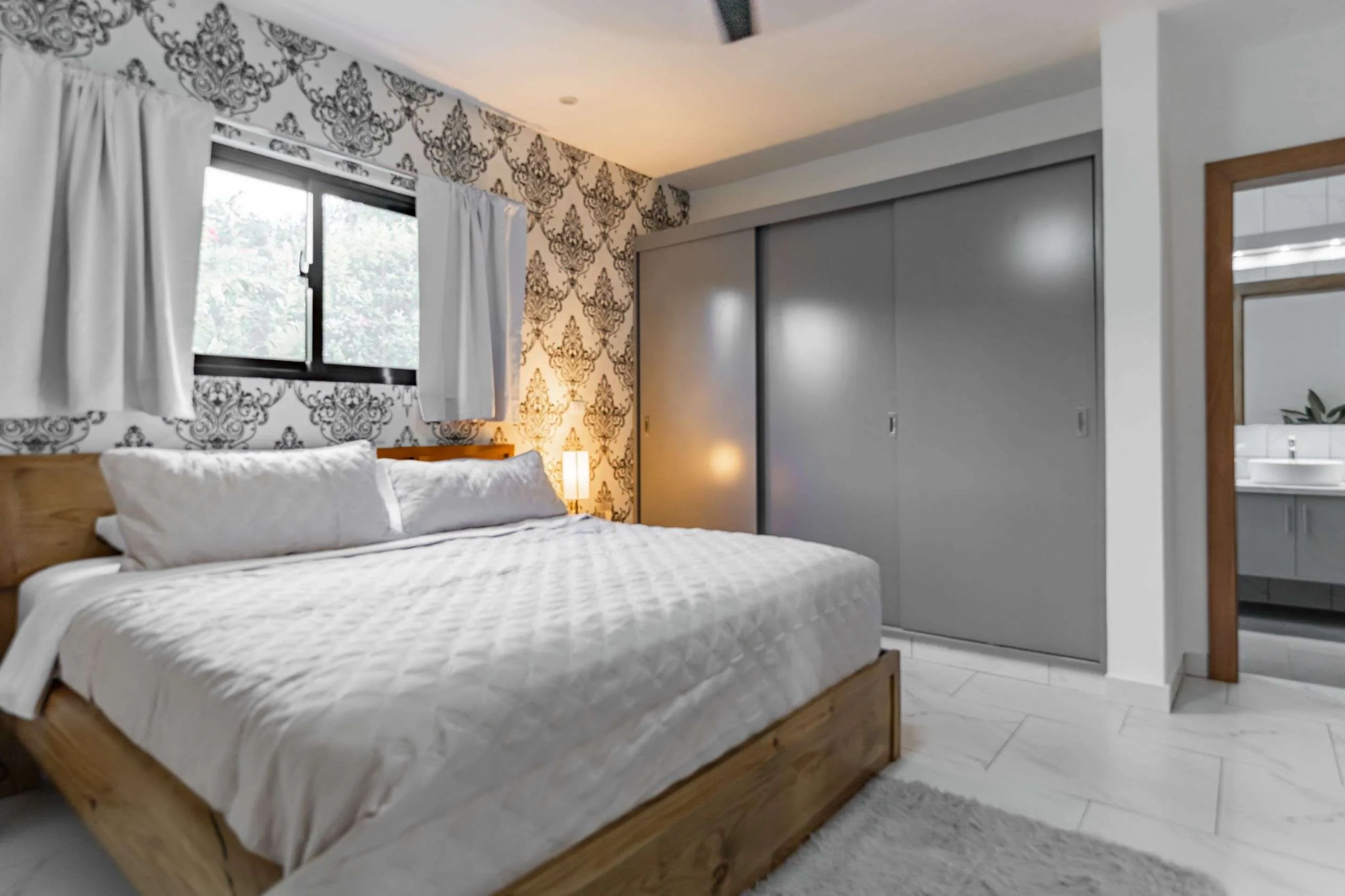 3BR Villa Sunseeker Casa Linda master bedroom with wood bed and patterned wallpaper.