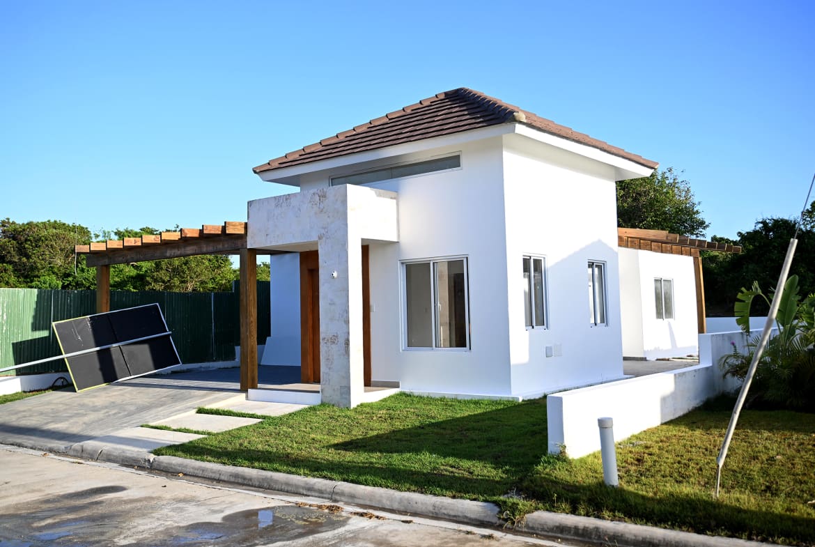 Modern white house with wooden pergola and green lawn