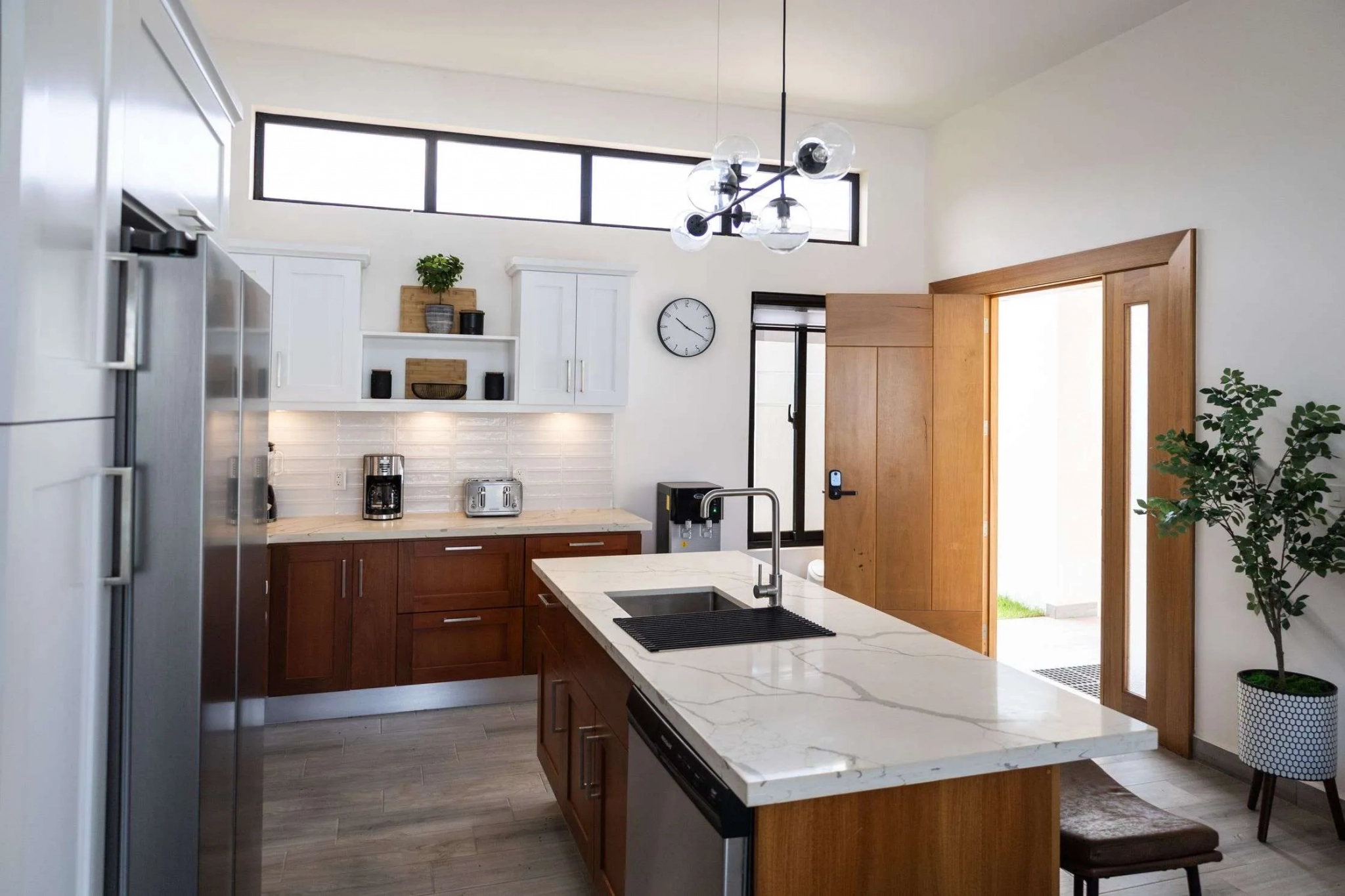 buyDRproperty Modern kitchen with white cabinets, wood island, and stainless steel appliances. Sosua Real Estate