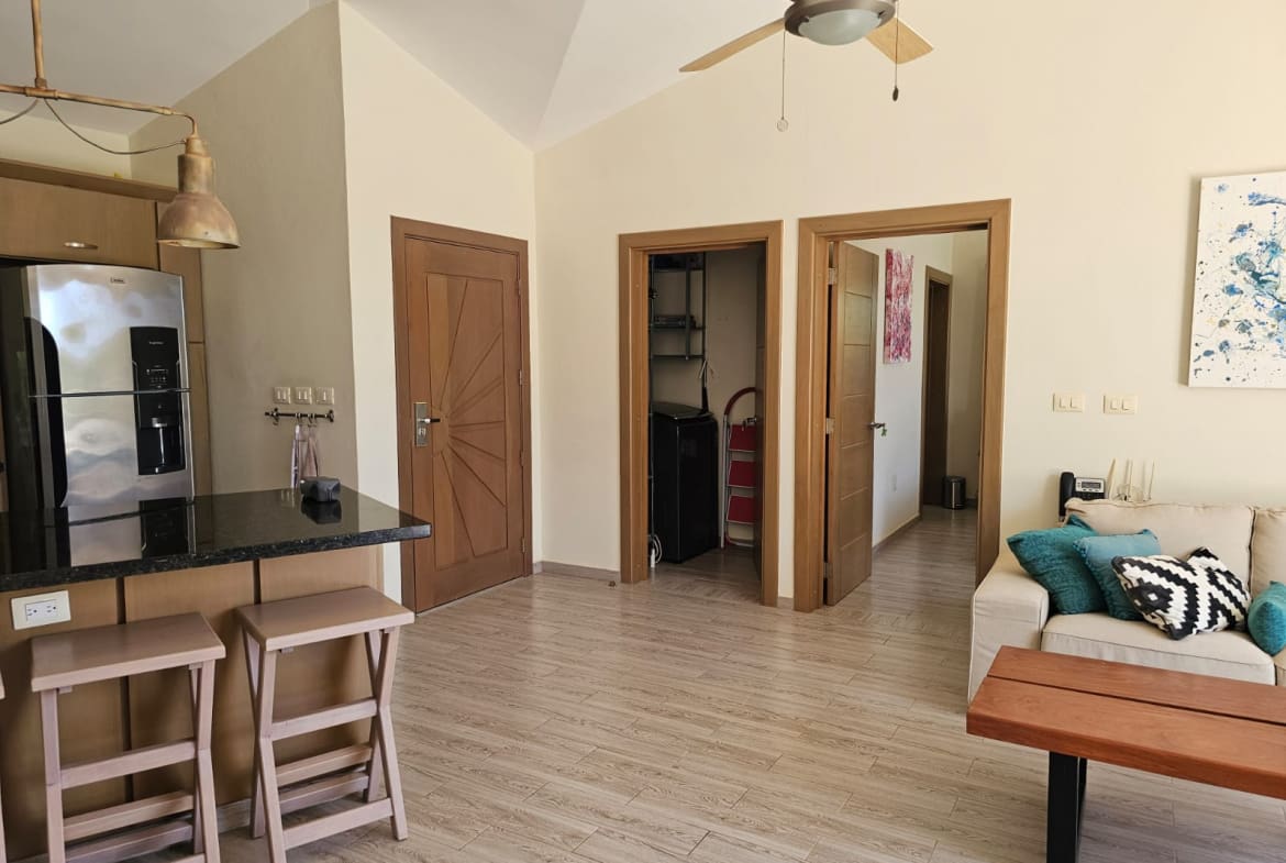 buyDRproperty Modern kitchen and living area with stainless steel refrigerator, island, and sofa. Sosua Real Estate