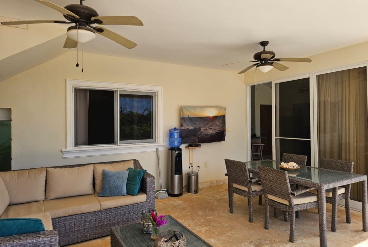 buyDRproperty Covered patio with seating, dining table, water cooler, and ceiling fans. Sosua Real Estate
