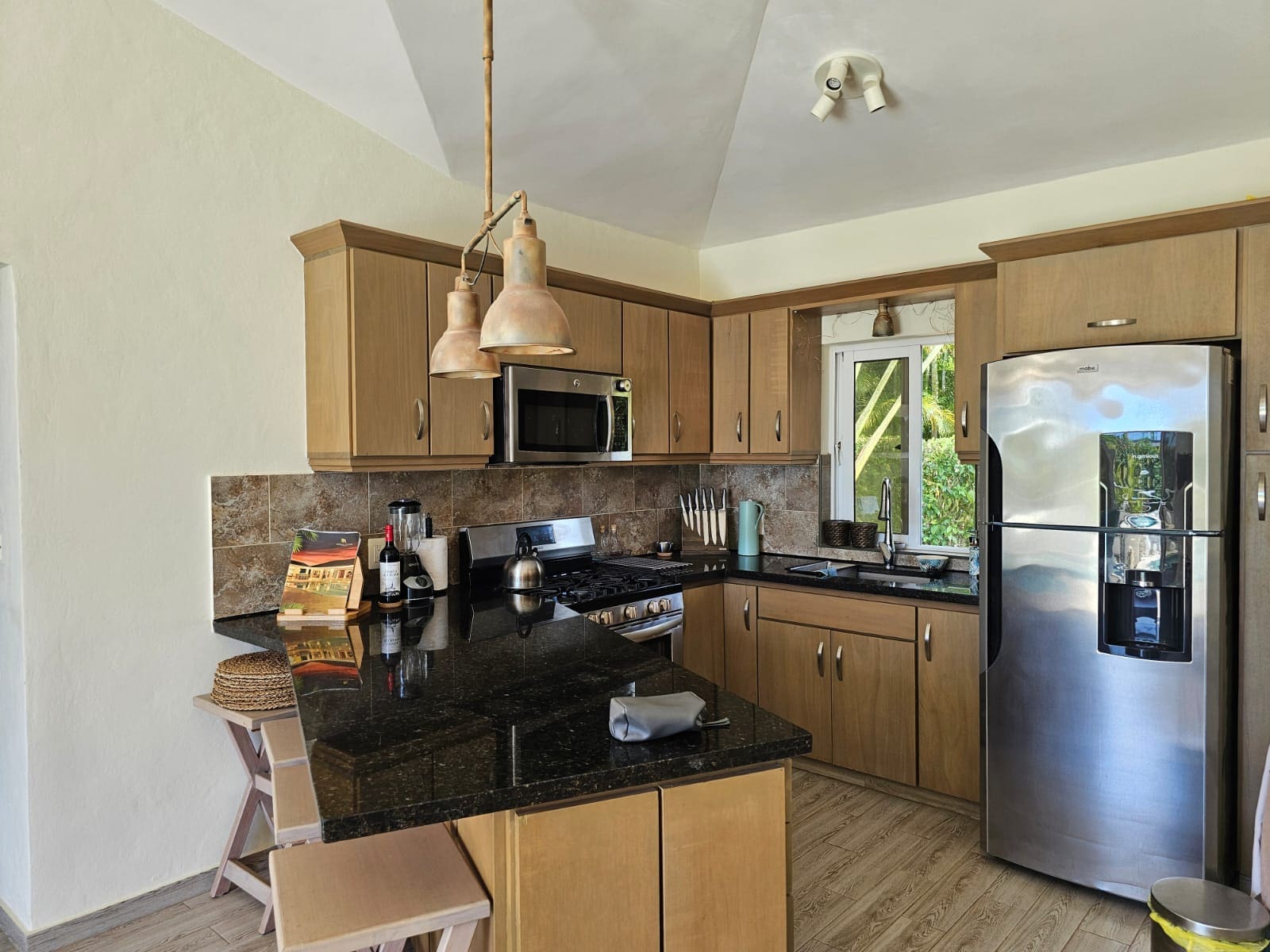 buyDRproperty Modern kitchen with granite countertops, stainless steel appliances, and wood cabinetry. Sosua Real Estate