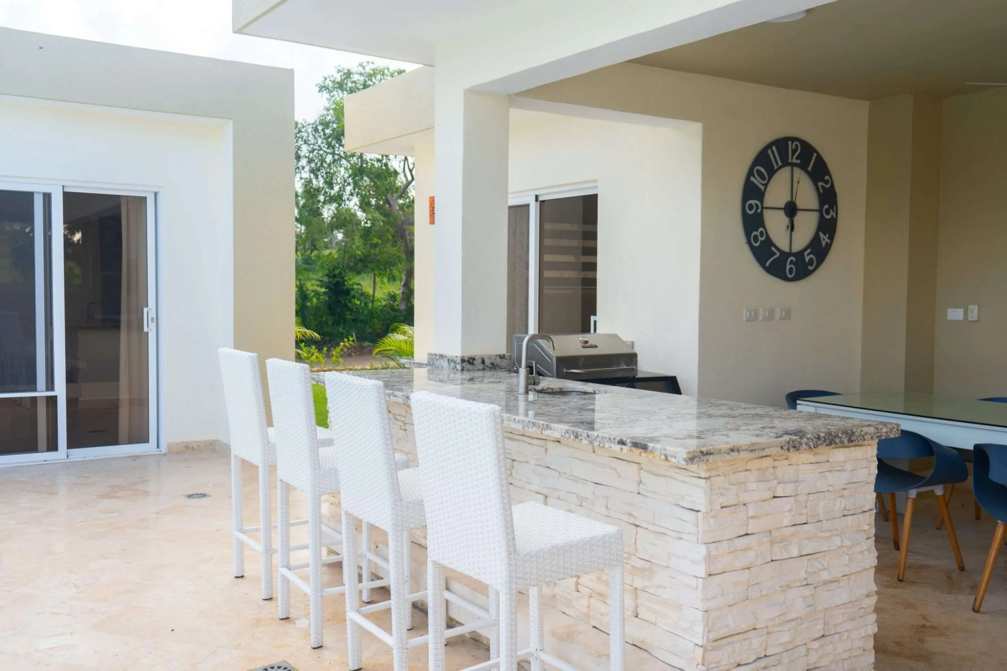 buyDRproperty Outdoor kitchen bar with white stools, granite countertop, and grill Sosua Real Estate