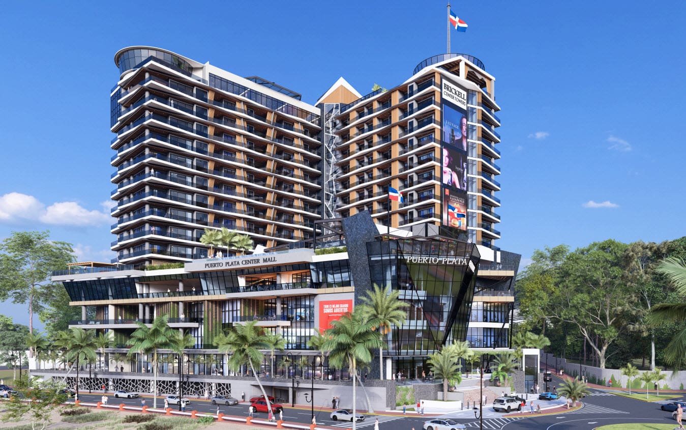 Modern mixed-use shopping complex with two tall towers and a glass atrium, labeled Puerto Plata Center Mall, set against a blue sky with palm trees.
