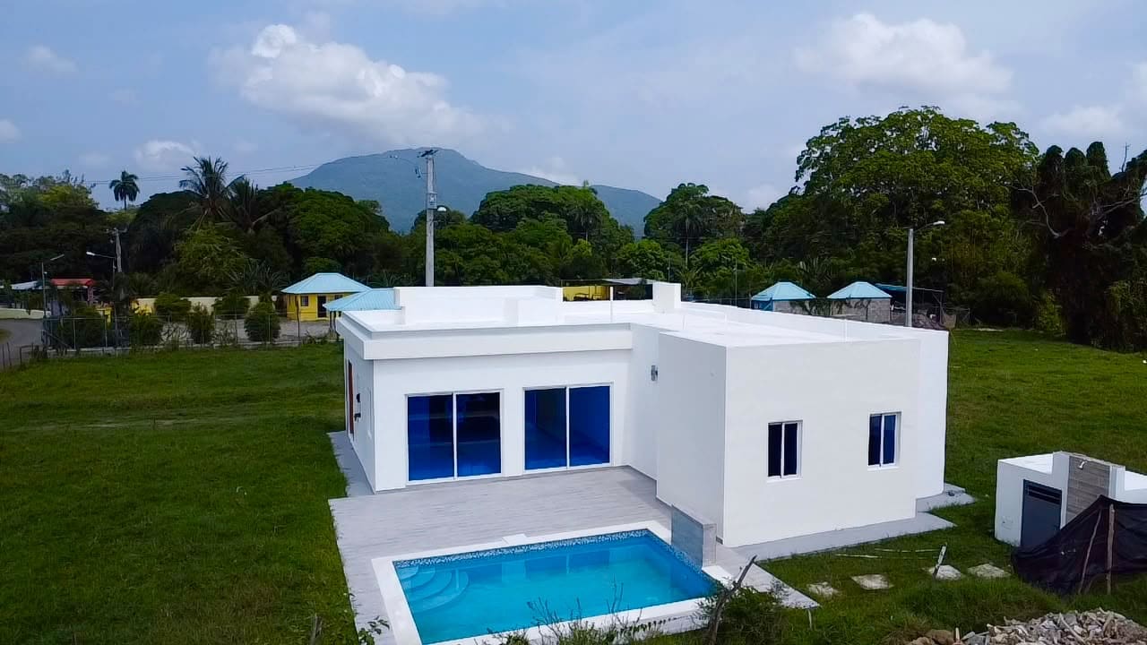 Modern white house with blue-windowed doors and a swimming pool Sosua Real Estate