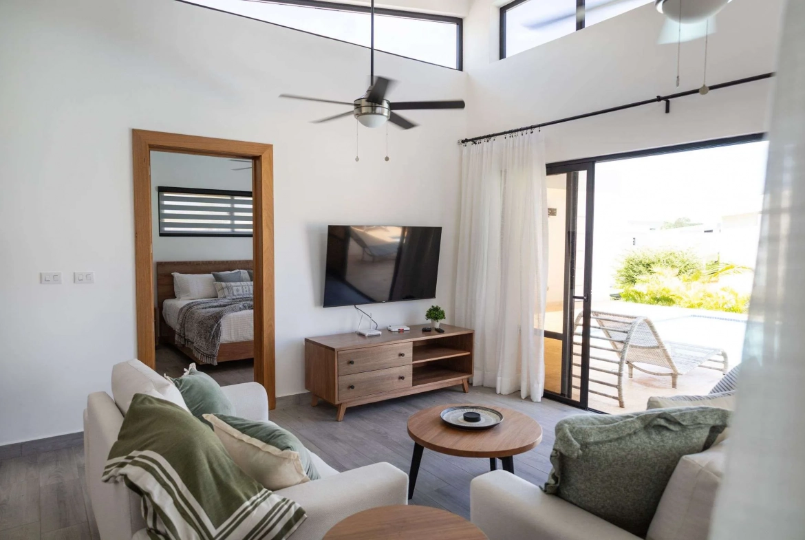 buyDRproperty Modern living room with white couches, TV, and view of a pool Sosua Real Estate