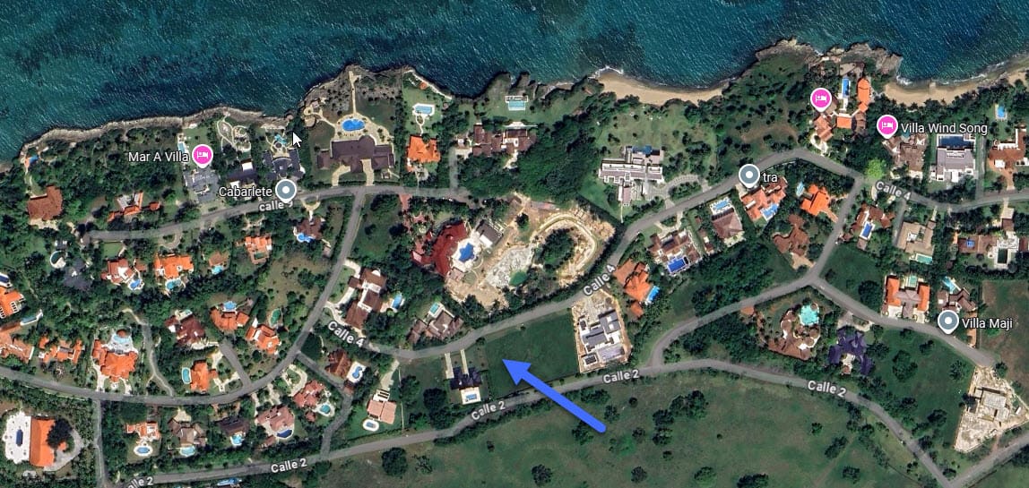 Aerial view of luxury villas and coastal properties along a tropical shoreline.